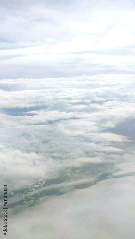 White wavy clouds in a blue sky, an open view from an airplane window White wavy clouds in a blue sky, an open view from an airplane window