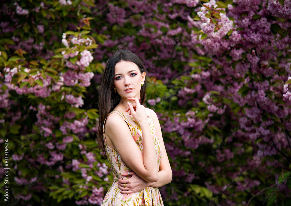 portrait of sensitive beautiful brunette woman with tattoo on her neck in dress in the garden near blossoming sakura flowers portrait of sensitive beautiful brunette woman with tattoo on her neck in dress in the garden near blossoming sakura flowers