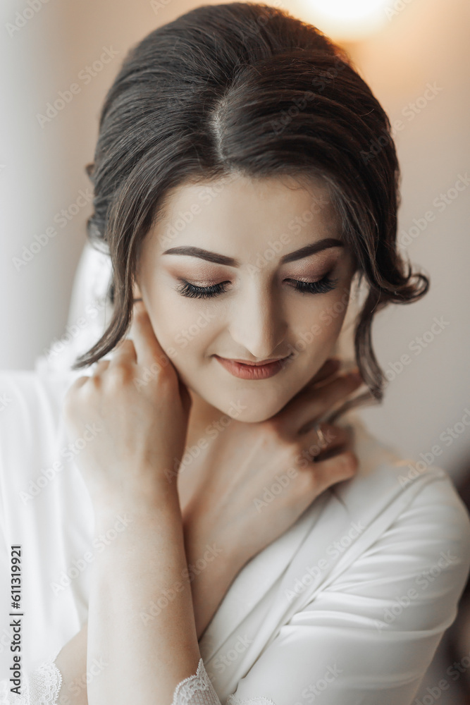 Portrait of a brunette bride touching her face. Gorgeous make-up and hair. Voluminous veil. Wedding photo. Beautiful bride Portrait of a brunette bride touching her face. Gorgeous make-up and hair. Voluminous veil. Wedding photo. Beautiful bride