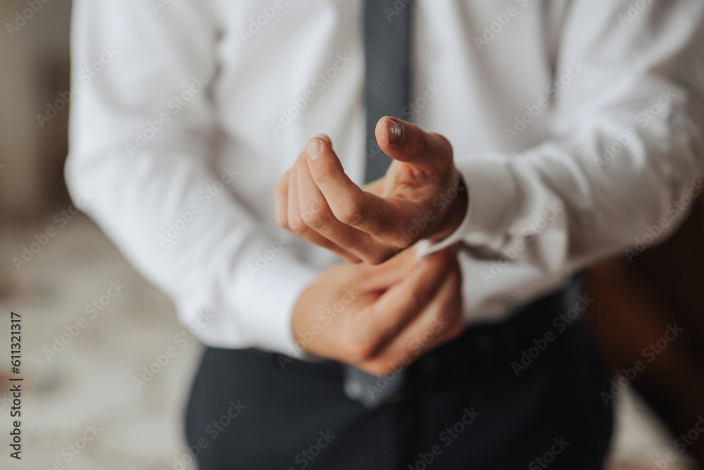 Fototapeta premium cropped photo of stylish man buttoning white shirt. Front view. A stylish watch. Men's style. Fashion. Business