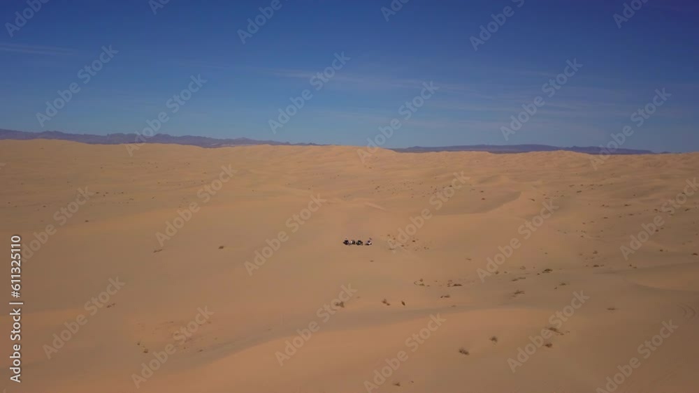 Aerial Shot Of Sand Vehicles On Dunes Against Sky, Drone Descending Forward Over Desert Landscape With Mountain Range - Glamis, California Aerial Shot Of Sand Vehicles On Dunes Against Sky, Drone Descending Forward Over Desert Landscape With Mountain Range - Glamis, California