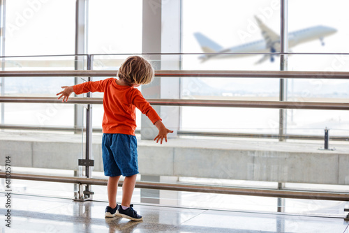 фотографія Young child watches a plane take off from an airport window