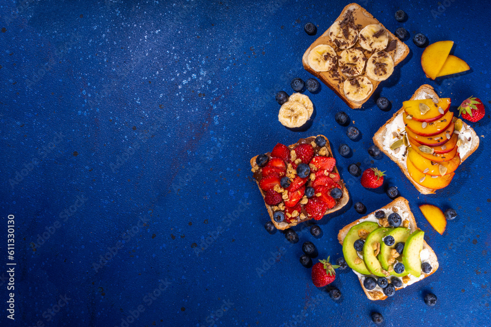Fruit berry sandwiches. Various toasts with peanut butter, cream cheese, chocolate spread with summer berries and fruits - strawberry, banana, peach, apple, blueberry, Tasty morning lunch food