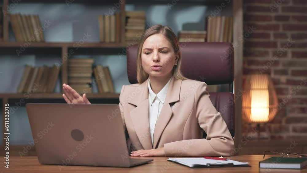 Ambitious company director conducting video conference on laptop with colleagues and denying all new ideas. Determined lady felling disappointed with employees underperformance. Ambitious company director conducting video conference on laptop with colleagues and denying all new ideas. Determined lady felling disappointed with employees underperformance.