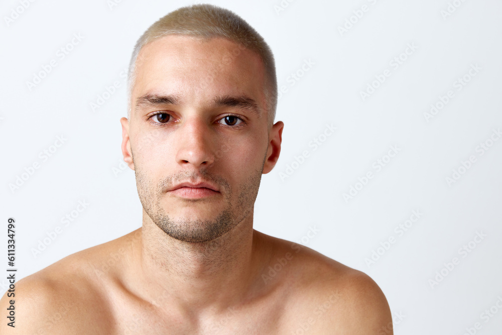 Handsome young shirtless man with clear, spotless skin looking at camera against white studio background. Concept of men's beauty, skincare, cosmetology, spa, health. Copy space for ad Handsome young shirtless man with clear, spotless skin looking at camera against white studio background. Concept of men's beauty, skincare, cosmetology, spa, health. Copy space for ad