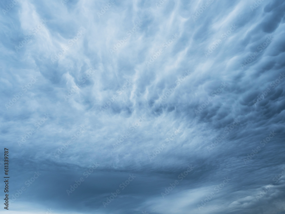 Dramatic blue sky with clouds. Spooky abstract background pattern texture. Horror, Halloween, evil, armagedon, apocalypse concept. Dramatic blue sky with clouds. Spooky abstract background pattern texture. Horror, Halloween, evil, armagedon, apocalypse concept.