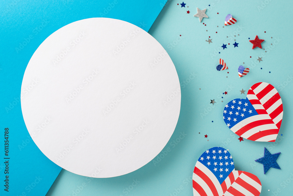 Fototapeta premium Presidents' Day USA artistic greetings. Top view of patriotic decor: hearts with American flag-inspired pattern, glimmering stars, confetti on bicolor blue surface with empty circle for text or ad