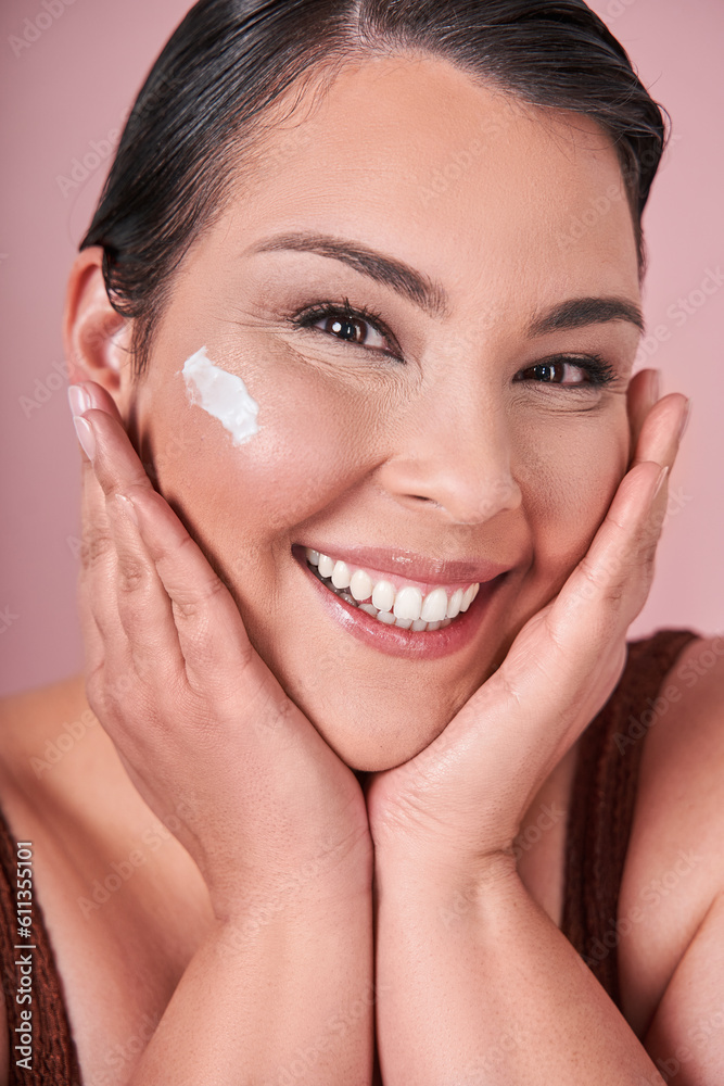 Vertical view of the optimistic female millennial with bare shoulders smiling with moisturizing cream Vertical view of the optimistic female millennial with bare shoulders smiling with moisturizing cream
