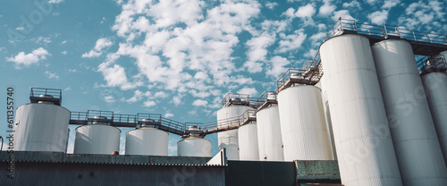 Agricultural silos. Storage and drying of grains, wheat, corn, soy, sunflower. Industrial building exterior. Big metallic silver containers close-up. Background of agricultural tanks with copy space.