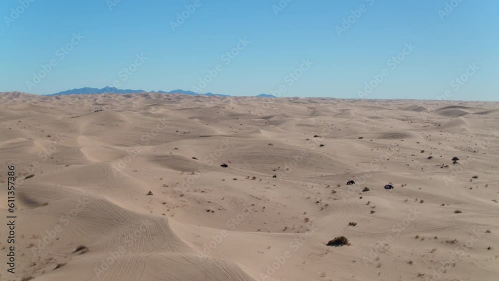 Aerial Panning Shot Of Sandrails Amidst Bushes On Sand Dunes Against Sky, Drone Flying Over Desert Landscape On Sunny Day - Glamis, California Aerial Panning Shot Of Sandrails Amidst Bushes On Sand Dunes Against Sky, Drone Flying Over Desert Landscape On Sunny Day - Glamis, California
