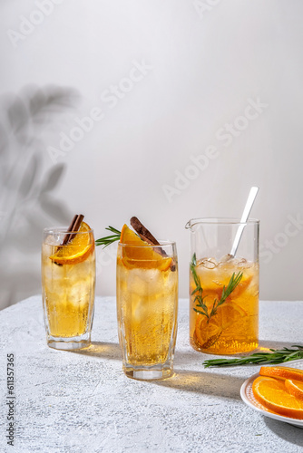 Fresh cocktail with orange, ice and herbs on the  table. Refreshing drink on a hot summer day. Ice tea. Sangria or punch in a glass