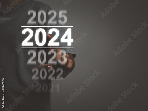 Happy new year 2024, businessman selecting year 2024 on virtual screen future growth For the upcoming year, goals, investments, returns, upcoming new businesses.