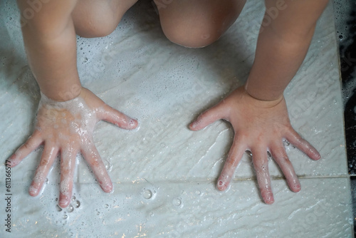 baby's hands holding bath foam.,Child's hands playing with soap in the bathroom © Apicha