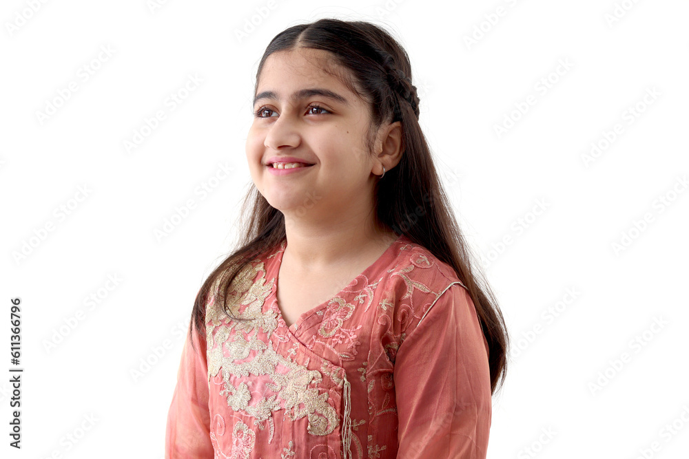 Portrait of cute happy smiling Indian girl child with long hair and beautiful eyes wearing traditional dress costume, standing isolated on white background, side view of Asian female kid Portrait of cute happy smiling Indian girl child with long hair and beautiful eyes wearing traditional dress costume, standing isolated on white background, side view of Asian female kid