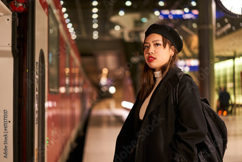 Beautiful multiracial woman looking away while standing at terminal train station