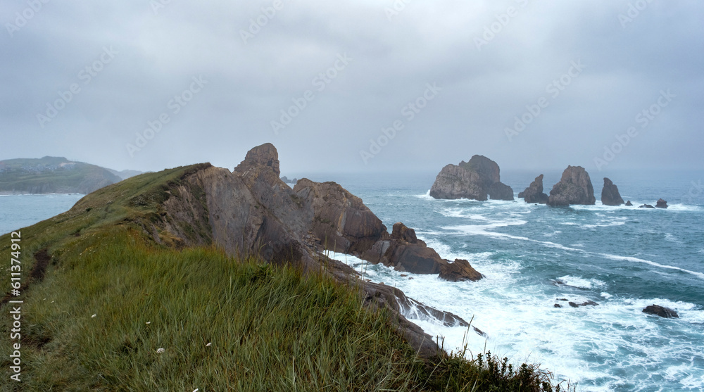 Coastal landscape with steep cliffs and rock formations carved out by wave action