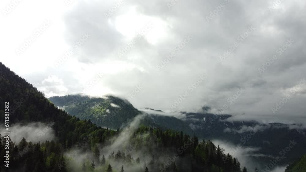Aerial drone view of lake and green forest in national park. Clouds laying on mountains. Scenic View of water in a lake with pine trees. Mountain lake with morning fog Aerial drone view of lake and green forest in national park. Clouds laying on mountains. Scenic View of water in a lake with pine trees. Mountain lake with morning fog