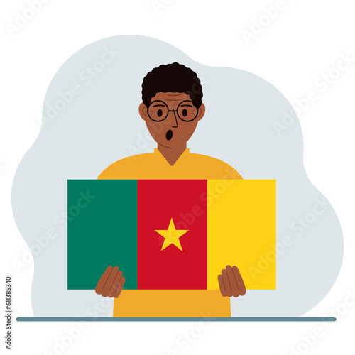 A man holds the flag of Cameroon in his hands. The concept of demonstration, national holiday or patriotism. Nationality.