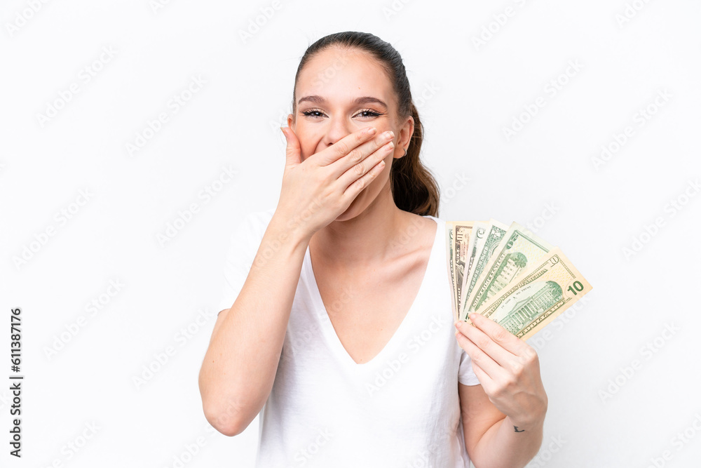 Young caucasian woman taking a lot of money isolated on white background happy and smiling covering mouth with hand Young caucasian woman taking a lot of money isolated on white background happy and smiling covering mouth with hand