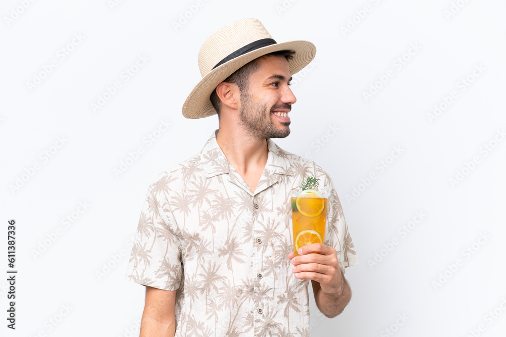 Young caucasian man holding a cocktail isolated on white background looking side Young caucasian man holding a cocktail isolated on white background looking side