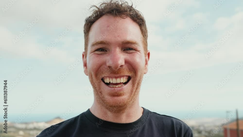 Happy Caucasian young man smiling in front of camera at house rooftop Happy Caucasian young man smiling in front of camera at house rooftop
