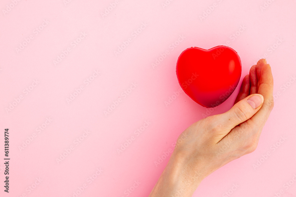 Medical insurance concept with red heart in female hands, top view Medical insurance concept with red heart in female hands, top view