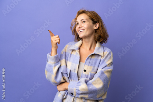 Young Georgian woman isolated on purple background pointing up a great idea