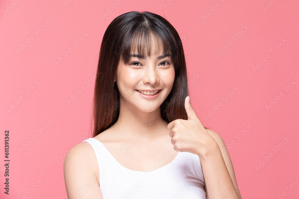 Beautiful Attractive Asian young woman smile and making good sign thumbs up feeling so happiness and confident,Isolated on pink background,Beauty Concept Beautiful Attractive Asian young woman smile and making good sign thumbs up feeling so happiness and confident,Isolated on pink background,Beauty Concept