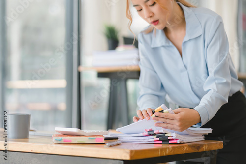 Принти на полотні A businesswoman is sifting through stacks of paper files and folders that contain both incomplete and completed documents