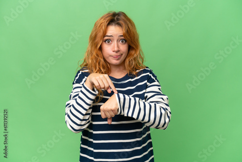 Young caucasian woman isolated on green screen chroma key background making the gesture of being late