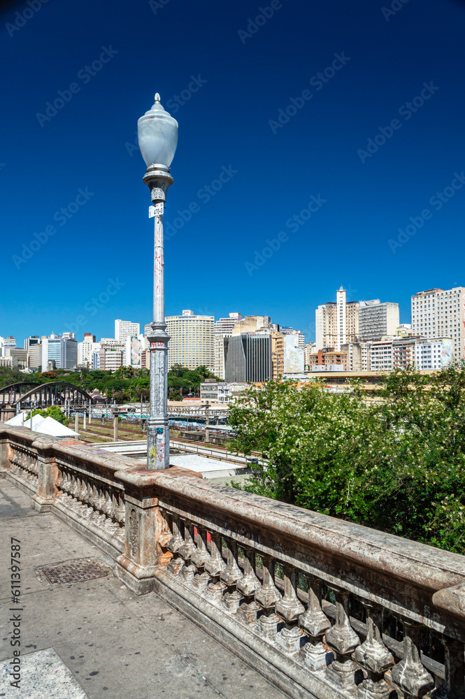 Light pole on Rua Sapucaí in Belo Horizonte. Viaduct Santa Teresa. Commercial and residential buildings. Beautiful blue sky. Vertical.