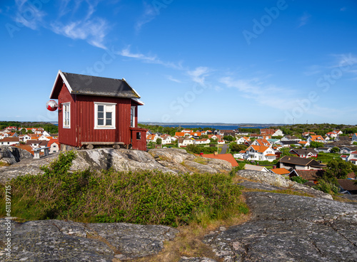 Red swedish wooden cottage on the top of the hill and a view at the cityscape of the island Vrango in Sweden, near the Gothenburg