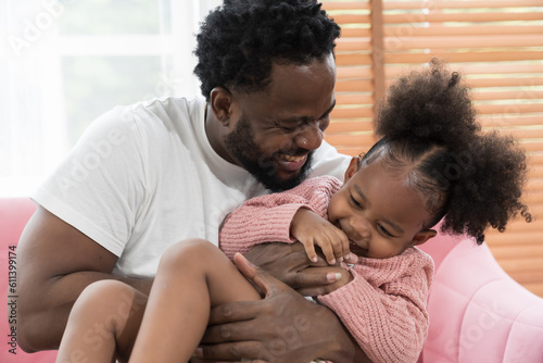 Father and daughter playing together at home. Happy African American little girl kid playing with dad. Happy African American family spending time together