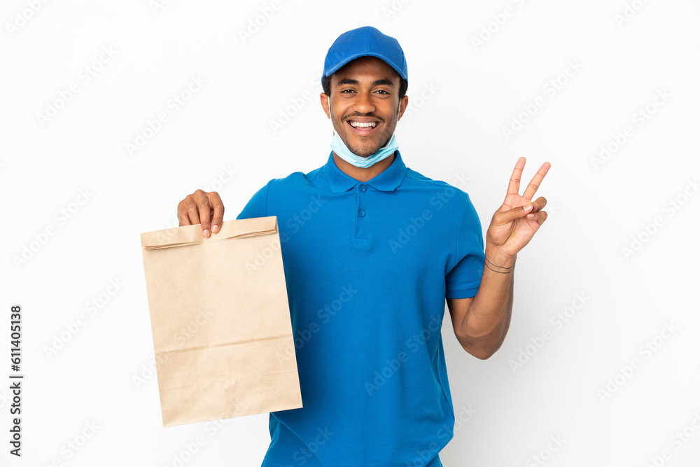 African American man taking a bag of takeaway food isolated on white background smiling and showing victory sign African American man taking a bag of takeaway food isolated on white background smiling and showing victory sign