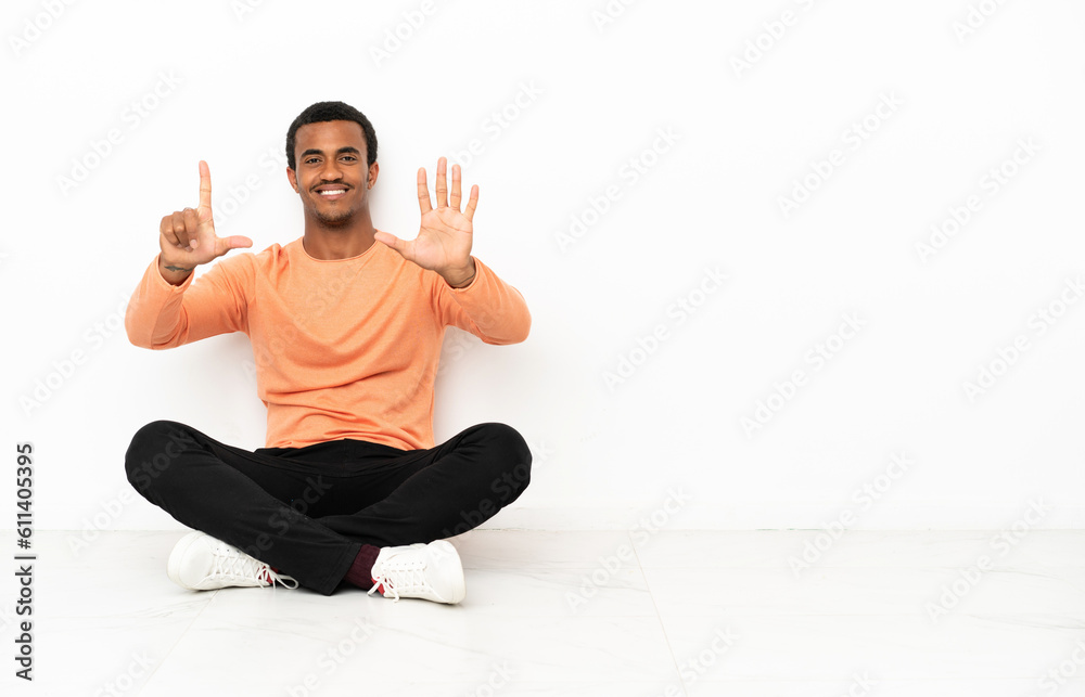 African American man sitting on the floor over isolated copyspace background counting seven with fingers African American man sitting on the floor over isolated copyspace background counting seven with fingers