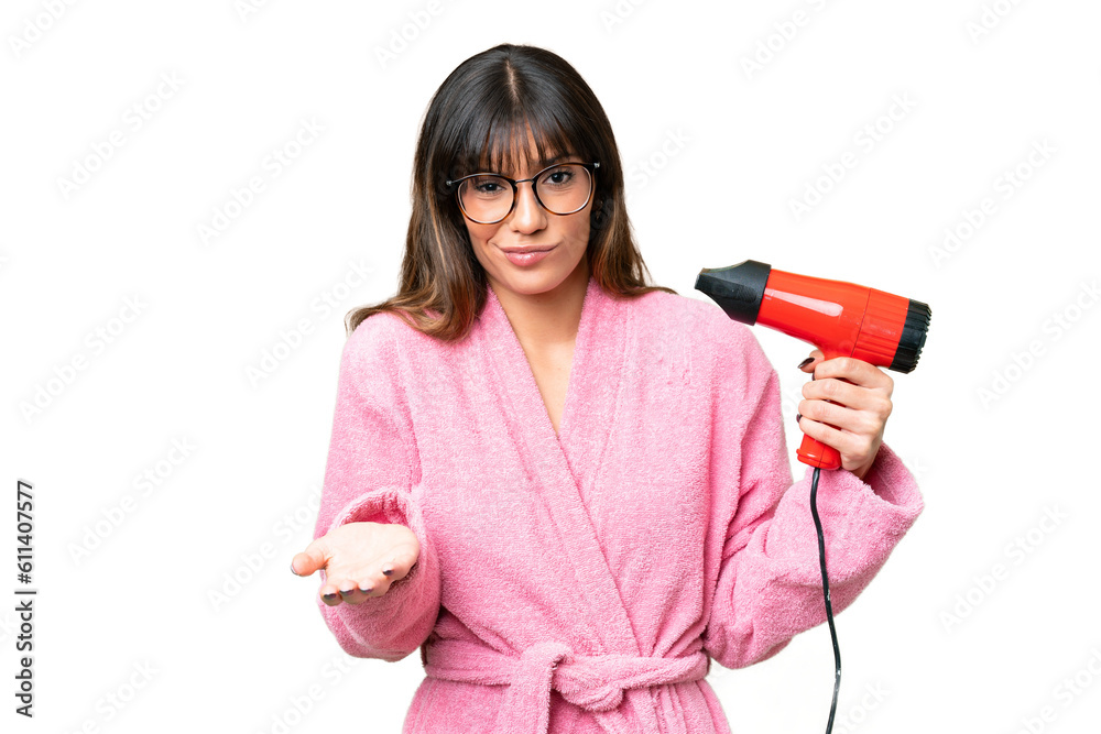 Young caucasian man holding a hairdryer over isolated chroma key background making doubts gesture while lifting the shoulders Young caucasian man holding a hairdryer over isolated chroma key background making doubts gesture while lifting the shoulders