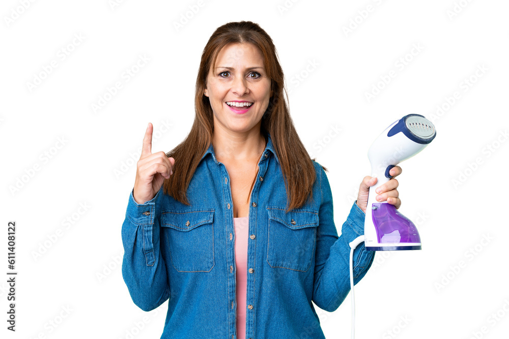 Middle age woman holding an iron over isolated background pointing up a great idea Middle age woman holding an iron over isolated background pointing up a great idea