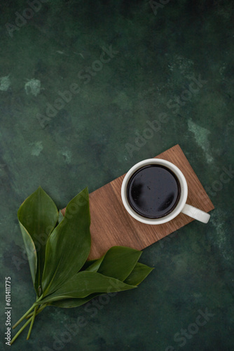 A cup of aromatic delicious coffee in a white cup on a green background.
