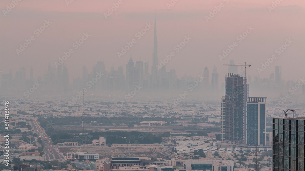 Dubai Downtown skyline row of skyscrapers with tallset tower aerial night to day timelapse. UAE