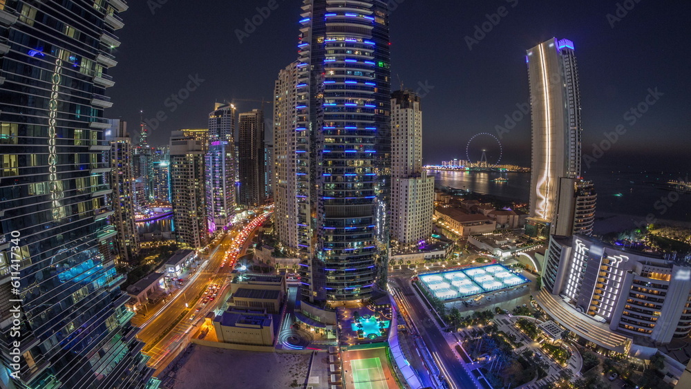 Obraz premium Panorama of the Dubai Marina and JBR area and the famous Ferris Wheel aerial day to night timelapse