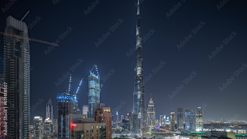 Fototapeta premium Panorama showing aerial cityscape night timelapse with illuminated architecture of Dubai downtown.