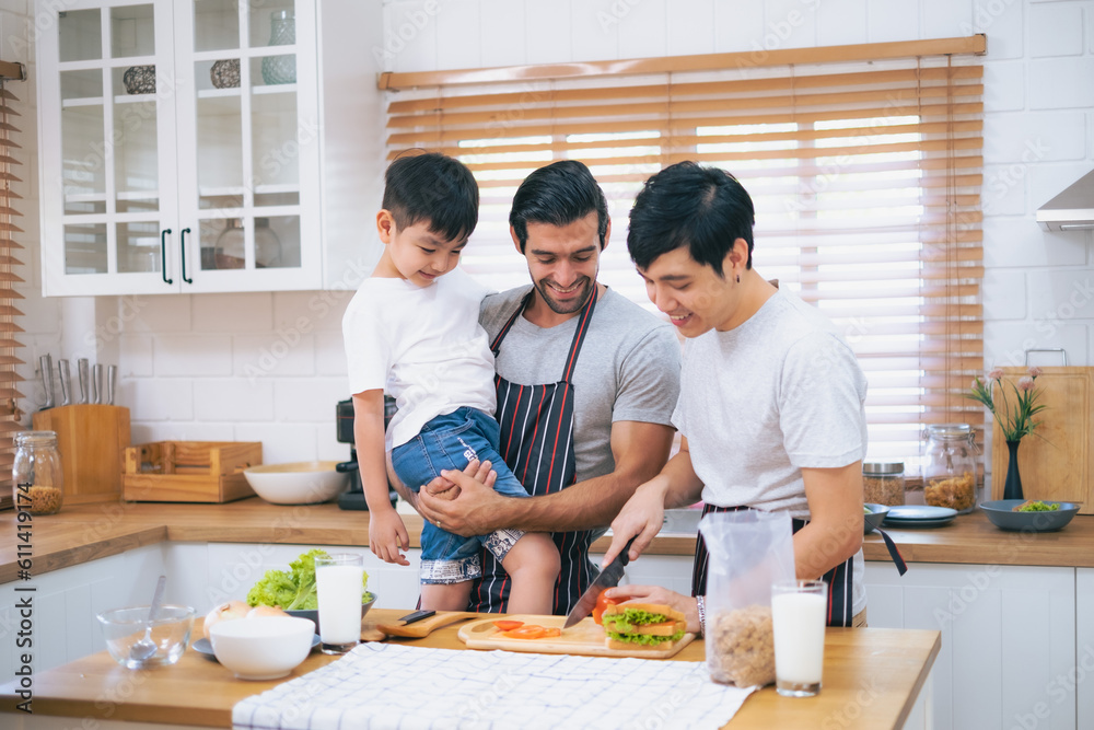 Fatherhood carry Asian boy looking asian man making food at counter in kitchen at home in morning with smile of happiness.