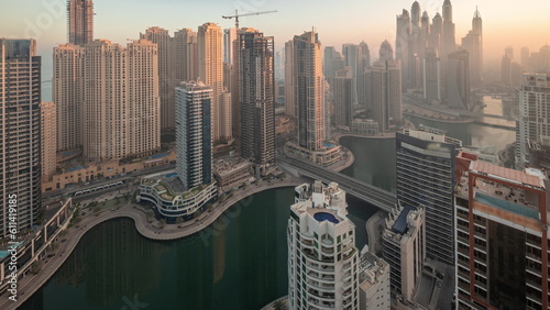 View of various skyscrapers in tallest recidential block in Dubai Marina aerial night to day timelapse photo