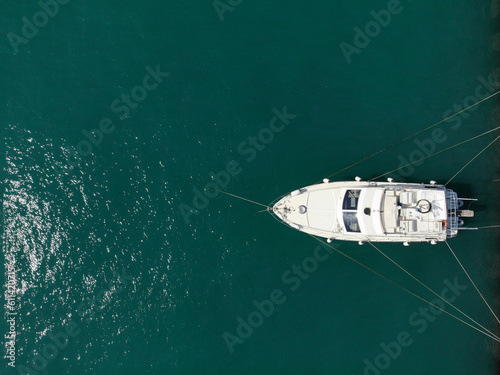 Aerial top view of white moored boat or yacht at dock, view from above. Copy space