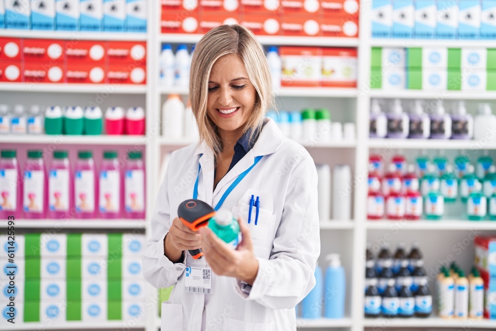 Young blonde woman pharmacist scanning medication bottle at pharmacy Young blonde woman pharmacist scanning medication bottle at pharmacy