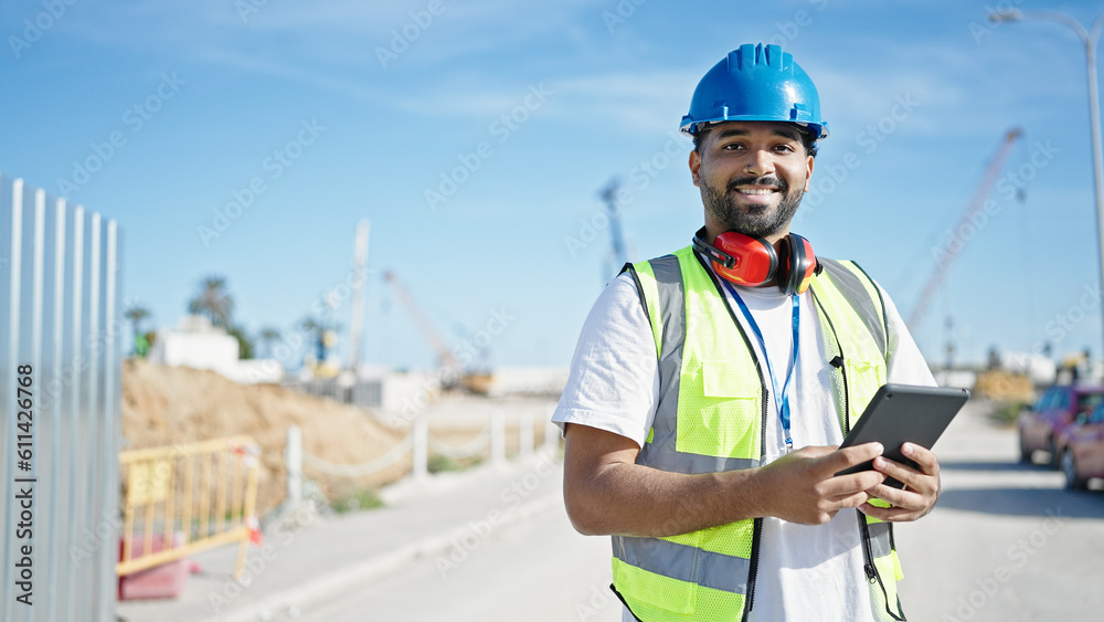 African american man builder smiling confident using touchpad at street