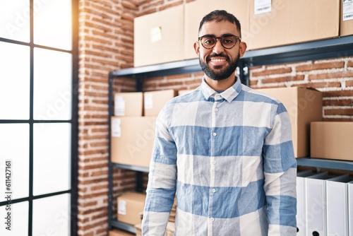 Young hispanic man ecommerce business worker smiling confident standing at office