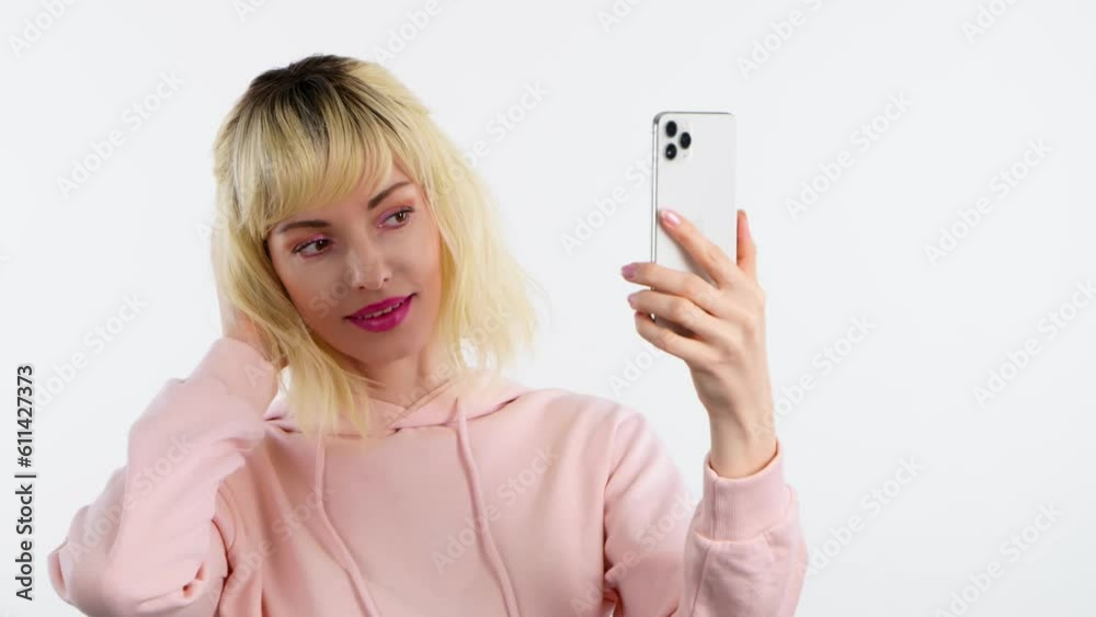 Selfie, pose and woman with phone, peace sign for social media post. Fashionable blonde lady with mobile smartphone posing smiling, taking profile picture, studio shot isolated on white background Selfie, pose and woman with phone, peace sign for social media post. Fashionable blonde lady with mobile smartphone posing smiling, taking profile picture, studio shot isolated on white background