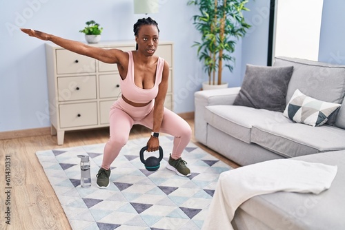 African american woman using kettlebell training at home