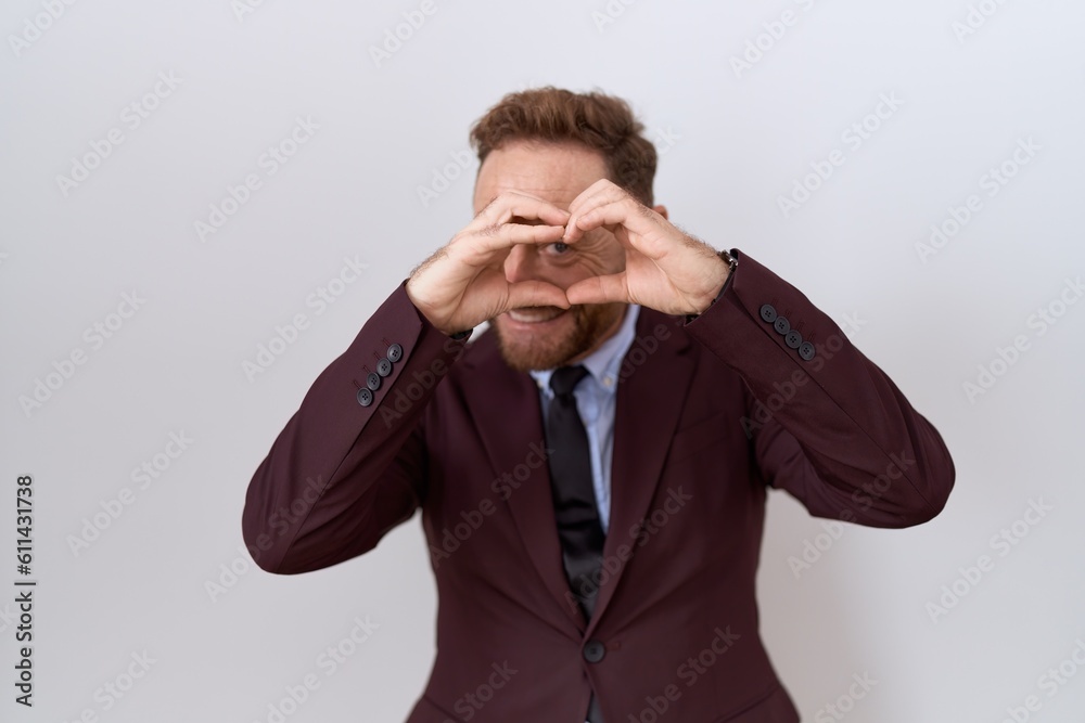Middle age business man with beard wearing suit and tie doing heart shape with hand and fingers smiling looking through sign Middle age business man with beard wearing suit and tie doing heart shape with hand and fingers smiling looking through sign